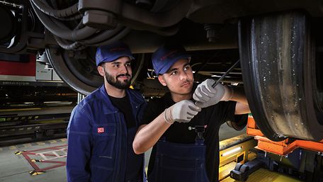 Zwei männliche Azubi Mechatroniker auf der Arbeit
