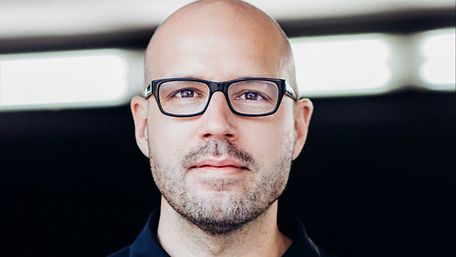 Ein Mann mit Brille schaut frontal in die Kamera